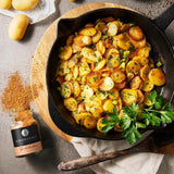 Brathähnchen Gewürz neben Pfanne mit Bratkartoffeln