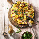 Bauernfrühstück auf einem Holztablett mit Besteck.