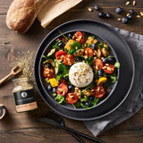 Burrata Salat mit Ofengemüse auf einem dunklen Teller serviert.