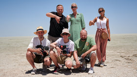 Ein Ankerkraut Team steht zum Gruppenfoto in einer kargen Landschaft und Posen vor der Kamera.