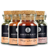 Korkengläser mit Gewürzen des kleinen Grill Gewürz-Sets nebeneinander auf weißem Hintergrund.