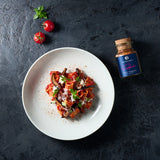 Pasta alla norma auf einem weißen Teller angerichtet.