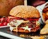 BBQ Burger Rezept: Servierter Burger mit Patatas Bravas und Strauchtomaten
