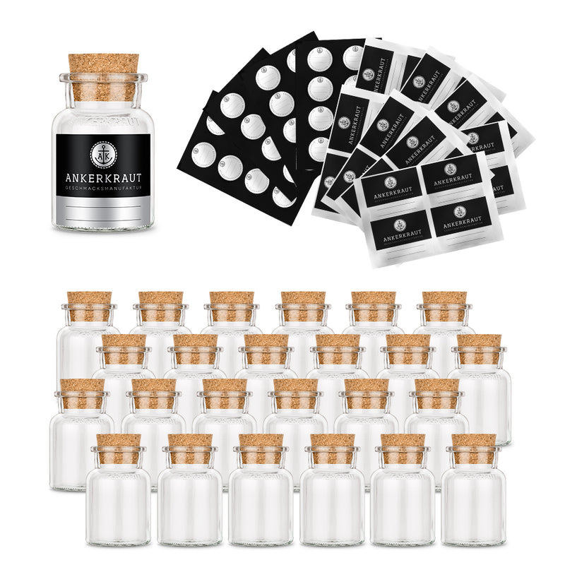 Vierundzwanzig leere Korkengläser mit Etiketten von Ankerkraut auf weißem Hintergrund.