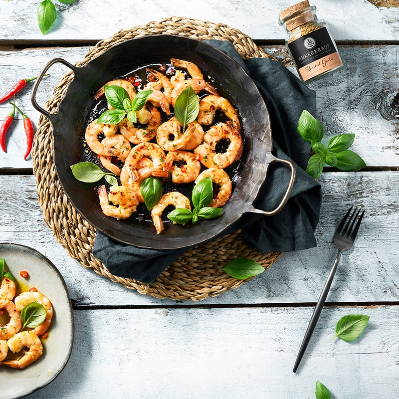Roasted Garlic neben Garnelen in der Pfanne