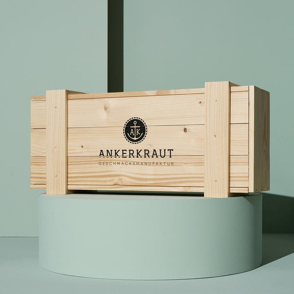 Deluxe Adventskalender vor grünem Hintergrund auf Podest