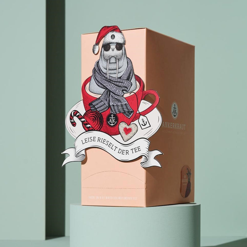 Tee Adventskalender vor grünem Hintergrund auf Podest