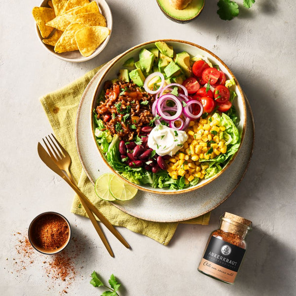 Taco Salat mit Chili Con Carne Gewuerz auf einem tiefen Teller.