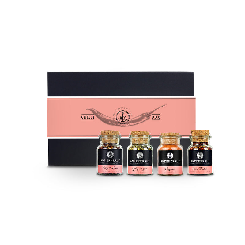 Chili Geschenkset von Ankerkraut mit vier Korkengläsern vor einer Geschenkbox mit Chilischote auf der Banderole.