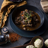 Saftiges Gulasch auf einem tiefen Teller angerichtet und mit Petersilie garniert.