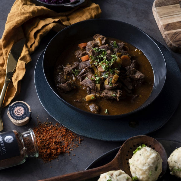 Saftiges Gulasch auf einem tiefen Teller angerichtet und mit Petersilie garniert.