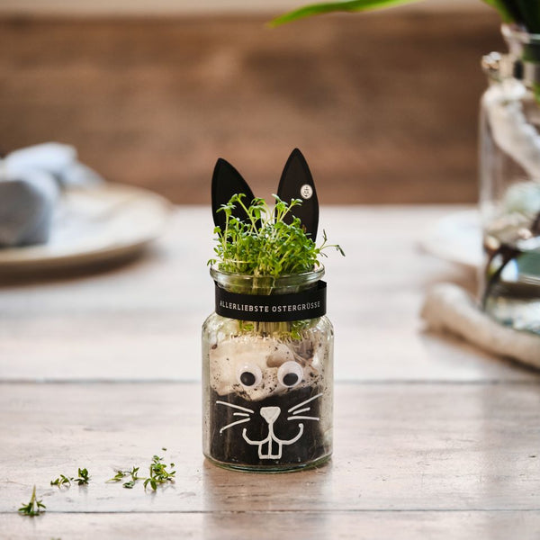 Kleines Korkenglas als Ostedeko mit Ohren aus Pappe und einem aufgemahlten Gesicht.