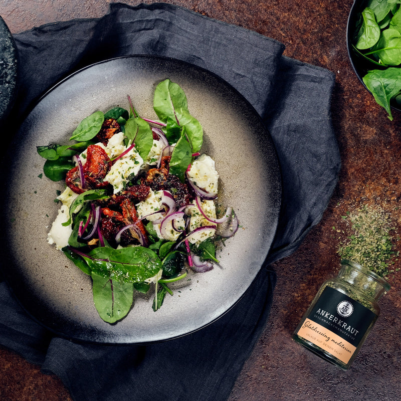 Frischer Salat mit getrockneten Tomaten, roten Zwiebeln, Feta und mediterranem Salatdressing von Ankerkraut.