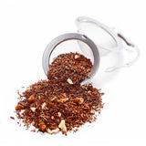 Ankerkraut Orange-Maracuja Rotbuschtee als Häufchen in einem offenen Teesieb.