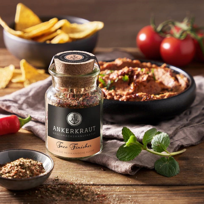 Ankerkraut Taco Gewürz im Korkenglas, vor einer Schale mit Dip und Nacho Chips.