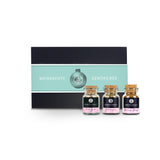 Türkise XMAS Geschenk-Box aus schwarzem Karton mit drei Korkengläsern davor.